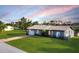 Charming single-story home with a well-manicured lawn and a colorful driveway, exuding curb appeal at 15099 Community Ave, Port Charlotte, FL 33953