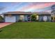 Charming single-story home features a well-manicured lawn and arched entryway at 15099 Community Ave, Port Charlotte, FL 33953