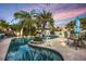 Outdoor pool area with tropical landscaping, poolside dining and recreation at 15099 Community Ave, Port Charlotte, FL 33953
