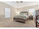 Cozy bedroom with neutral tones featuring a ceiling fan, carpeted floor, and natural light at 15425 Long Cypress Dr, Ruskin, FL 33573