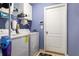 Functional laundry room equipped with washer, dryer, shelving, and storage solutions at 15425 Long Cypress Dr, Ruskin, FL 33573