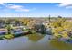 Aerial shot showcasing waterfront living with a lake, lush trees, and surrounding residential neighborhood at 1549 San Christopher Dr, Dunedin, FL 34698