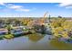 Aerial view of waterfront home with mature trees, dock, and lake views at 1549 San Christopher Dr, Dunedin, FL 34698