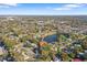 Aerial shot shows the property's proximity to a serene lake and the surrounding neighborhood at 1549 San Christopher Dr, Dunedin, FL 34698