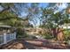 Serene backyard with a wooden deck, lush greenery, and mature trees at 1549 San Christopher Dr, Dunedin, FL 34698
