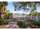 Backyard deck with white railing, lush landscaping, and a serene lake view at 1549 San Christopher Dr, Dunedin, FL 34698