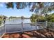 Charming backyard deck overlooking the lake with white railings and mature trees at 1549 San Christopher Dr, Dunedin, FL 34698
