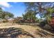 Landscaped backyard featuring a wooden fence, mature trees, and a peaceful outdoor space at 1549 San Christopher Dr, Dunedin, FL 34698