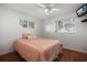 Bright bedroom features hardwood floors, a ceiling fan, and natural light from the windows at 1549 San Christopher Dr, Dunedin, FL 34698
