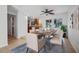 Bright dining room featuring a ceiling fan, kitchen access, and a dining table set for six at 1549 San Christopher Dr, Dunedin, FL 34698