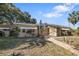 Exterior view of home featuring a screen enclosed porch and brick paver walkway at 1549 San Christopher Dr, Dunedin, FL 34698
