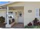 Charming front entrance with decorative door, brick accents, and well-maintained landscaping, enhancing curb appeal at 1549 San Christopher Dr, Dunedin, FL 34698