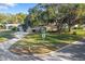 Charming single-story home with a well-manicured lawn and mature trees shading the property at 1549 San Christopher Dr, Dunedin, FL 34698