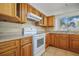 Well-lit kitchen features wood cabinets, tile backsplash, and modern appliances at 1549 San Christopher Dr, Dunedin, FL 34698