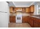 Well-lit kitchen features wood cabinets, tile backsplash, and modern appliances at 1549 San Christopher Dr, Dunedin, FL 34698