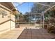 Outdoor patio with tiled flooring and screened enclosure, offering views of the landscaped backyard at 1549 San Christopher Dr, Dunedin, FL 34698