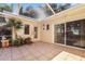 Screened patio with tile flooring, providing a serene outdoor space surrounded by tropical plants at 1549 San Christopher Dr, Dunedin, FL 34698