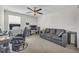 The bedroom features a gray sofa, ceiling fan, neutral walls, carpet flooring, and a window at 1785 Broad Winged Hawk Dr, Ruskin, FL 33570