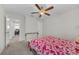 Simple bedroom features carpet flooring, a ceiling fan, a window and a bed with floral-patterned bedding at 1785 Broad Winged Hawk Dr, Ruskin, FL 33570