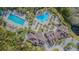 Aerial view of a community pool area featuring multiple pools, lounge chairs, and meticulously maintained landscaping at 19140 Sunset Bay Dr, Land O Lakes, FL 34638