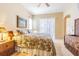 Bright bedroom featuring a bed with floral comforter, wooden dressers and lamps with lots of natural light at 19140 Sunset Bay Dr, Land O Lakes, FL 34638