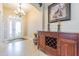 Elegant foyer with marble floors, chandelier, and a decorative wood console table with wine rack at 19140 Sunset Bay Dr, Land O Lakes, FL 34638