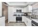 Updated kitchen with granite countertops, white cabinets, stainless steel appliances, and new floors at 2175 Corinne S Ct # A, St Petersburg, FL 33712