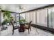 Bright sunroom featuring tile floors, a glass table, two chairs, a ceiling fan, and several plants at 2175 Corinne S Ct # A, St Petersburg, FL 33712