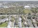 Aerial view showcasing a mix of residential homes, commercial properties, and a lake in the distance at 2312 Tallyho Ln, Palm Harbor, FL 34683