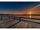 Sunset lake view from a wooden dock with secure railings, inviting relaxation and scenic beauty at 2321 Ecuadorian Way # 41, Clearwater, FL 33763