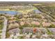 Aerial view of clustered homes with manicured lawns near golf course and lakes, showcasing a serene community setting at 2469 Nantucket Harbor Loop # 123, Sun City Center, FL 33573