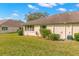 Backyard showcasing lush lawn, mature landscaping, and exterior features of the home at 2469 Nantucket Harbor Loop # 123, Sun City Center, FL 33573