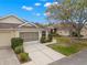Charming single-story home featuring a screen enclosed garage, well-maintained landscaping, and a welcoming walkway at 2469 Nantucket Harbor Loop # 123, Sun City Center, FL 33573