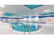 Bright indoor community pool with blue accents, multiple seating areas, and easy access at 2469 Nantucket Harbor Loop # 123, Sun City Center, FL 33573