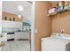 Laundry area with washer, overhead shelving, and view into kitchen at 2469 Nantucket Harbor Loop # 123, Sun City Center, FL 33573