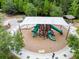 Aerial view of a shaded playground with slides and play equipment surrounded by mature trees at 32702 Natural Bridge Rd, Wesley Chapel, FL 33543