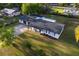 An aerial shot displays the home's roof and long driveway, surrounded by lush green landscaping at 38811 Inez Ave, Zephyrhills, FL 33542