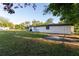 Large, verdant backyard featuring a fire pit and ample space for outdoor enjoyment and activities at 38811 Inez Ave, Zephyrhills, FL 33542