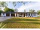 Charming single-story home with white painted brick, wood shutters, and a well-manicured front lawn at 38811 Inez Ave, Zephyrhills, FL 33542