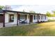 Welcoming covered front porch with seating and a wreath-adorned front door, perfect for relaxing at 38811 Inez Ave, Zephyrhills, FL 33542
