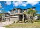 Two-story home with a well-maintained lawn, three-car garage, and a welcoming front entrance at 4917 Eagle Rock Dr, Wimauma, FL 33598