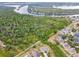 Scenic aerial view of neighborhood homes backing onto a lush green space and a winding waterway at 501 Washita Stone Dr, Ruskin, FL 33570