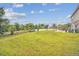 Large backyard with grassy area, perimeter fence, patio, and shade trees at 501 Washita Stone Dr, Ruskin, FL 33570