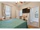 Comfortable bedroom with ensuite bathroom, large window with natural light and a wall-mounted television at 501 Washita Stone Dr, Ruskin, FL 33570