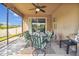 A covered patio with ceiling fan features seating with a view of the backyard at 501 Washita Stone Dr, Ruskin, FL 33570