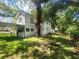View of the side and backyard of the home, showcasing the lawn and surrounding trees at 5121 40Th N Ave, St Petersburg, FL 33709