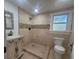 Updated bathroom with a stylish vanity, toilet, and walk-in shower with tan tiling at 5121 40Th N Ave, St Petersburg, FL 33709