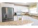 Bright kitchen with stainless steel refrigerator, white cabinets, and granite countertops at 6025 Shore S Blvd # 611, Gulfport, FL 33707