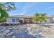 Charming single-story home featuring lush landscaping, a well-manicured lawn, and a welcoming entryway with double doors at 6324 Balboa Ln, Apollo Beach, FL 33572