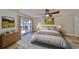 A beautifully staged bedroom has wood floors, neutral walls, and a sliding glass door to the backyard at 6324 Balboa Ln, Apollo Beach, FL 33572